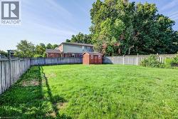 Expansive lawn with a perimeter fence and a storage shed - 