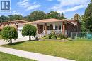 Brick exterior with a covered front porch featuring white railings, a front-facing attached garage, and a chain-link fence enclosing a portion of the yard - 2535 Privet Crescent, Mississauga, ON  - Outdoor 
