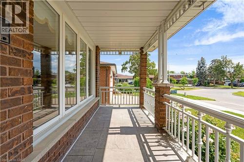 Brick exterior with a covered porch, featuring white railings, support columns, and large windows - 2535 Privet Crescent, Mississauga, ON - Outdoor With Deck Patio Veranda With Exterior