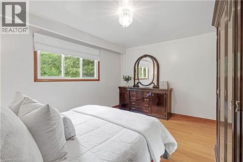 Hardwood flooring, recessed window with a Roman shade, ceiling-mounted light fixture, and white wall finishes - 2535 Privet Crescent, Mississauga, ON - Indoor Photo Showing Bedroom