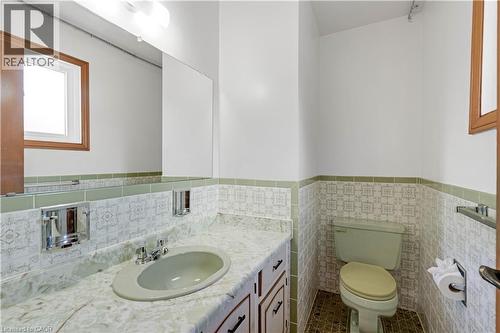 Wood-framed window with white trim, a vanity featuring an integrated sink, polished chrome faucet, and a wall-mounted mirror - 2535 Privet Crescent, Mississauga, ON - Indoor Photo Showing Bathroom