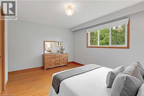 Hardwood flooring, natural wood window trim, overhead light fixture, light gray wall color, and white window coverings - 2535 Privet Crescent, Mississauga, ON - Indoor Photo Showing Bedroom