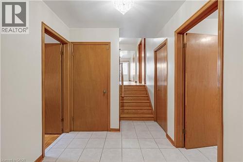 Tiled entryway with wood-finish doors and trim, featuring a staircase with wood-finish treads - 2535 Privet Crescent, Mississauga, ON - Indoor Photo Showing Other Room