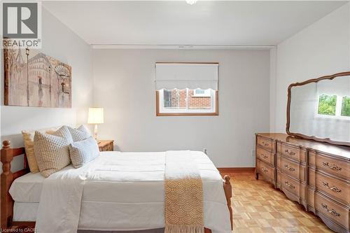 Light-toned walls, wood-finish flooring, and a window with wood trim - 2535 Privet Crescent, Mississauga, ON - Indoor Photo Showing Bedroom