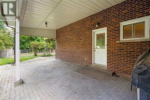 SIDE DOOR to Brick exterior, covered patio, paver hardscaping, exterior lighting, painted entry door with decorative glass - 2535 Privet Crescent, Mississauga, ON - Outdoor With Exterior