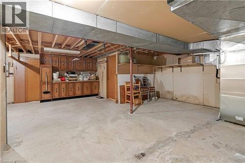 Spacious garage with concrete flooring, exposed beam ceiling, built-in wooden cabinetry and storage systems, and ample overhead clearance for vehicle and equipment storage - 2535 Privet Crescent, Mississauga, ON - Indoor Photo Showing Basement