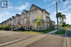 Multi-level townhome featuring brick and stone veneer, multiple gabled roofs, a covered entryway, and an attached garage - 