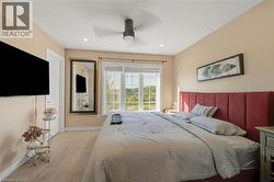 Vaulted ceiling with recessed lighting and ceiling fan, wood-finish flooring, and a large window - 