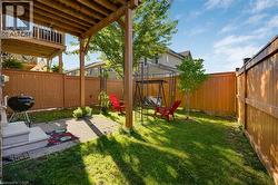Private backyard featuring a wooden privacy fence, mature trees, and a ground-level patio with steps - 