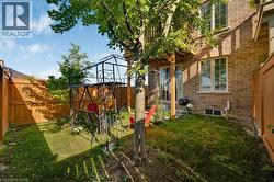 Enclosed backyard featuring a privacy fence, established tree, and a lower-level window - 