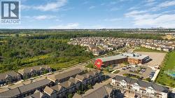Aerial perspective of a developed residential neighborhood featuring rows of townhomes and detached houses - 