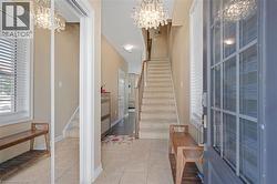 Foyer entry with tile flooring, sidelight window, and a built-in mirrored closet - 