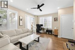 Recessed lighting, wood-finish flooring, white paneled door, and a ceiling fan - 