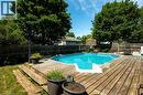 Expansive backyard featuring a large above-ground pool, surrounding wood-finish decking, and mature trees - 364 Stoneheight Place, Waterloo, ON 