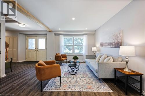 Wood-finish flooring throughout, recessed lighting, and a large window with white curtain panels - 364 Stoneheight Place, Waterloo, ON 