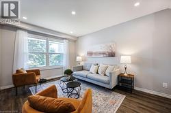Recessed ceiling lighting, wood-finish flooring, light-toned wall paint, and a large window with white trim - 