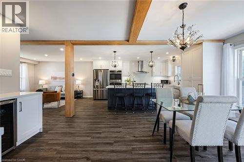 Open-concept living space with exposed wood beams, wood-finish flooring, recessed lighting, and a kitchen featuring stainless steel appliances - 364 Stoneheight Place, Waterloo, ON 