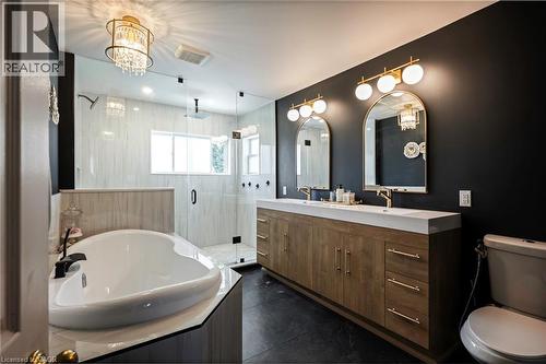 Dual vanity with gold-tone hardware, arched mirrors, and globe sconces - 364 Stoneheight Place, Waterloo, ON 