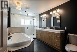 Dual vanity with gold-tone hardware, arched mirrors, and globe sconces - 