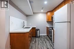 Wood-finish flooring, white countertops, stainless steel appliances, and wood cabinetry - 