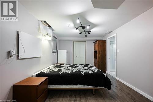 Wood-finish flooring, white walls, track lighting fixture, white paneled door, and a partially visible shower enclosure - 364 Stoneheight Place, Waterloo, ON 