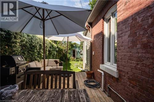 Expansive outdoor decking, red brick exterior, white window trim, and a green vine-covered wall - 29 Steven Street, Hamilton, ON 
