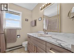 Full upper-level bathroom with a spacious vanity and natural light - 