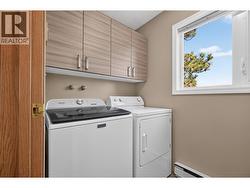 Convenient main-floor laundry with built-in cabinetry for added storage - 