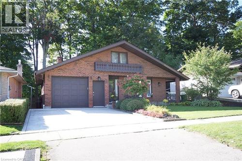 Brick exterior with a peaked roofline, a single-car garage, and a concrete driveway - 185 Southwood Drive, Kitchener, ON 