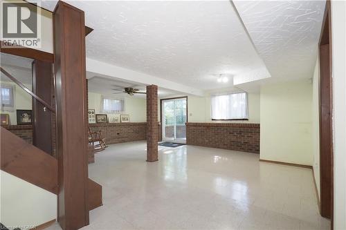 Lower-level space featuring light-toned flooring, exposed brick accents, and a sliding glass door - 185 Southwood Drive, Kitchener, ON 