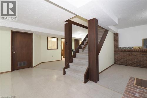 Carpeted staircase with dark wood-finish newel post and railings - 185 Southwood Drive, Kitchener, ON 