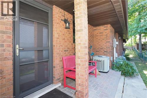 Brick exterior with a covered entry, screen door, and brick-patterned paving - 185 Southwood Drive, Kitchener, ON 