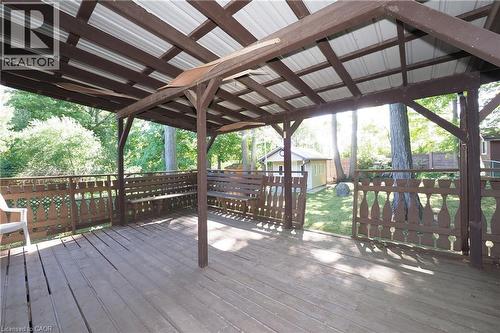 Covered wood deck featuring a metal roof, built-in wooden seating, and decorative wood railings - 185 Southwood Drive, Kitchener, ON 