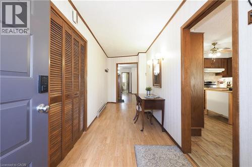 Entryway featuring wood-finish flooring, louvered bi-fold doors, and a paneled entry door with a digital keypad - 185 Southwood Drive, Kitchener, ON 