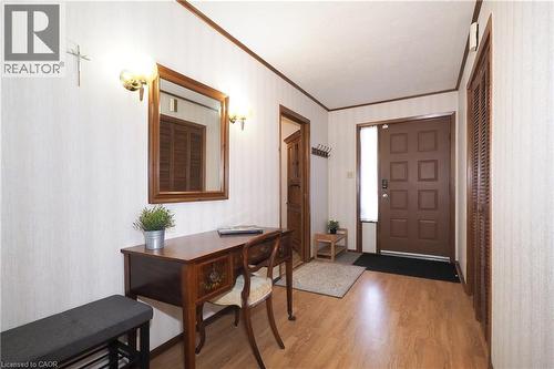Wood-finish flooring, paneled entry door with sidelight, and wood-finish bi-fold closet doors - 185 Southwood Drive, Kitchener, ON 