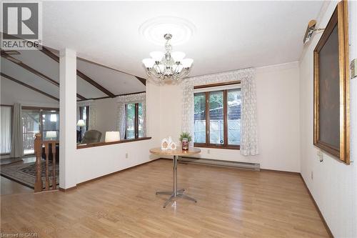 Vaulted ceilings with exposed beams, wood-finish flooring, built-in half wall, and a chandelier with a ceiling medallion - 185 Southwood Drive, Kitchener, ON 