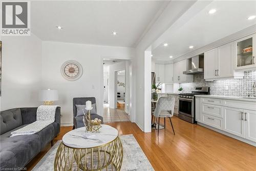 Recessed lighting, wood-finish flooring, white cabinetry, stainless steel appliances, and a tiled backsplash - 1373 Quest Circle, Mississauga, ON 