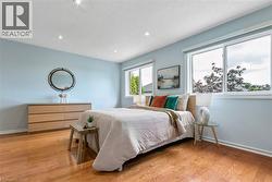 Recessed lighting, wood-finish flooring, and multiple windows with white trim - 