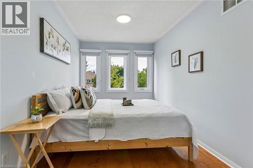 Warm wood-finish flooring, three paneled windows, and a ceiling-mounted light fixture - 1373 Quest Circle, Mississauga, ON 