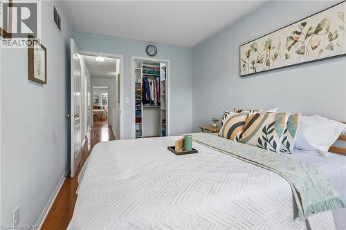Built-in closet with shelving and hanging storage, wood-finish flooring, and white interior doors - 1373 Quest Circle, Mississauga, ON 