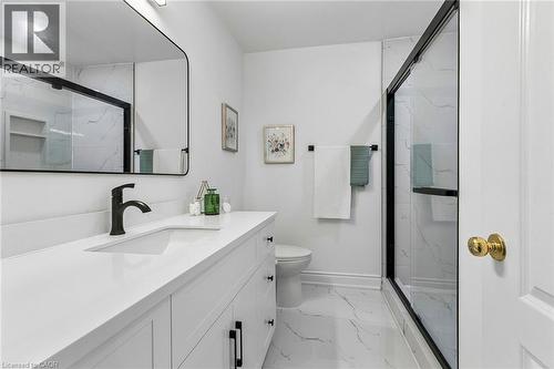 White vanity with integrated sink, black matte faucet, rectangular mirror, and a shower with black framed glass enclosure - 1373 Quest Circle, Mississauga, ON 