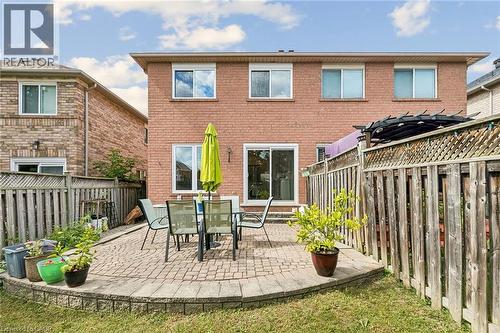 Brick exterior with multiple windows, sliding glass door, and paver patio - 1373 Quest Circle, Mississauga, ON 