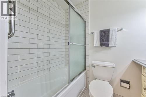 Main floor 4 pc bathroom with subway tiled tub to ceiling with glass doors. - 21 Vicmount Drive, Kitchener, ON 