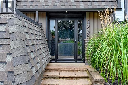Stone steps leading to a full-light entry door, complemented by a multi-tone shingle roof - 4236 Longmoor Drive, Burlington, ON 