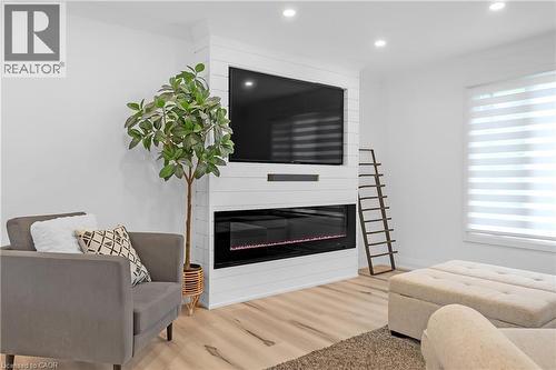 White shiplap-style media wall with an integrated linear electric fireplace - 4236 Longmoor Drive, Burlington, ON 