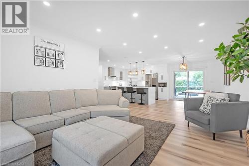 Recessed ceiling lighting, wood-finish flooring, sliding glass door, white cabinetry, stainless steel appliances - 4236 Longmoor Drive, Burlington, ON 