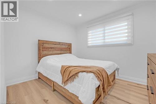 Recessed ceiling lighting, a large window with horizontal blinds, and wood-finish flooring - 4236 Longmoor Drive, Burlington, ON 