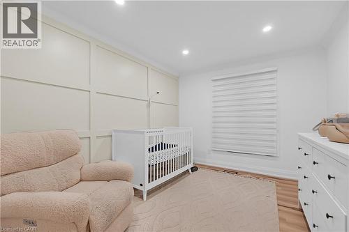 Accent wall with panel molding, recessed lighting, and wood-finish flooring - 4236 Longmoor Drive, Burlington, ON 