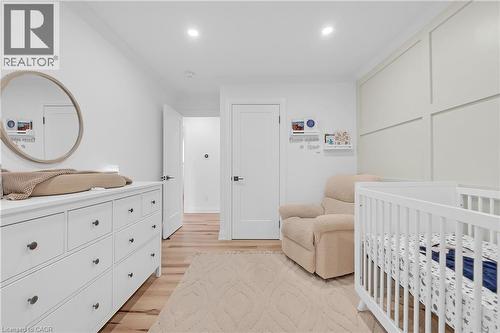 Recessed lighting, light wood-finish flooring, white paneled doors, and a decorative accent wall - 4236 Longmoor Drive, Burlington, ON 