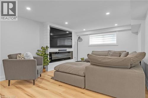 Wood-finish flooring, recessed lighting, and a built-in fireplace with a tile surround - 4236 Longmoor Drive, Burlington, ON 